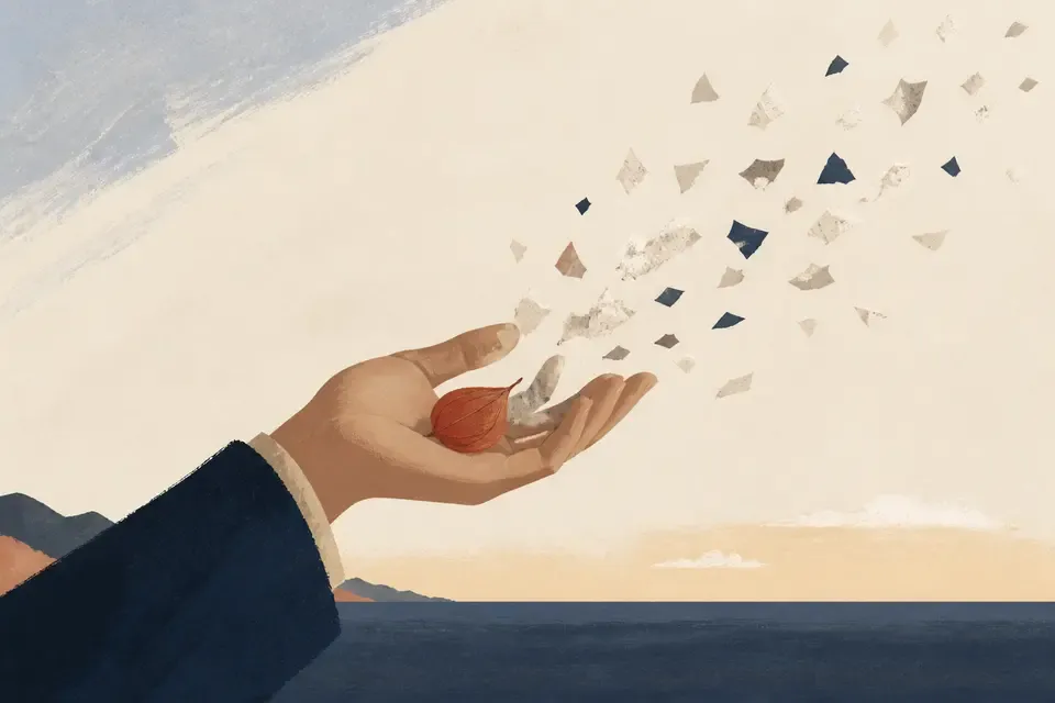 A hand releasing paper fragments while keeping one small object